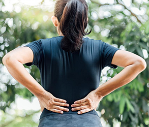 woman standing with lower back pain 