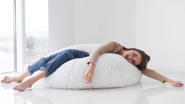 woman laying on bean bag at home