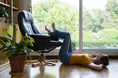 woman relaxing at home with feet on chair
