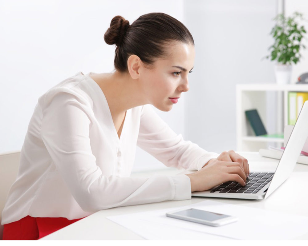 A female office worker experiencing postural fatigue and desk-related neck stiffness, a common condition treated with mobile sports and remedial massage in York.