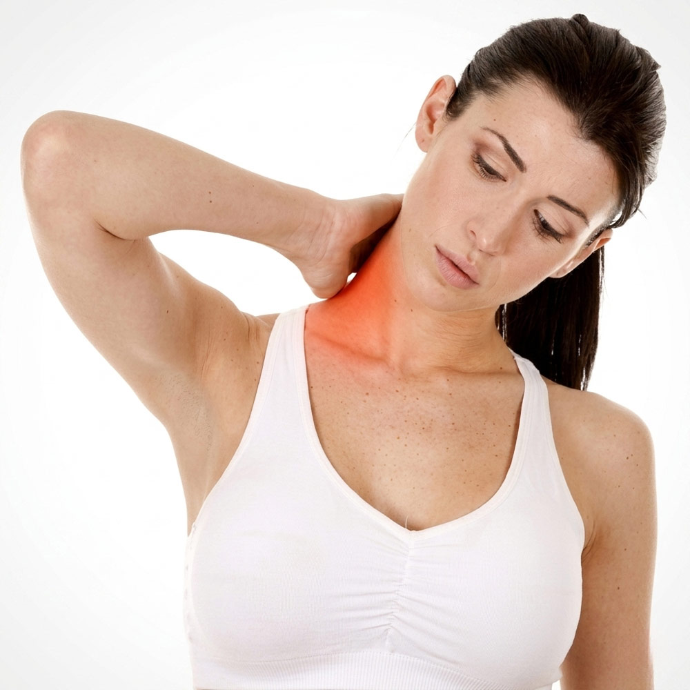 A woman holding her neck in discomfort, highlighting the tight upper trapezius muscles treated with sports and remedial massage in York.