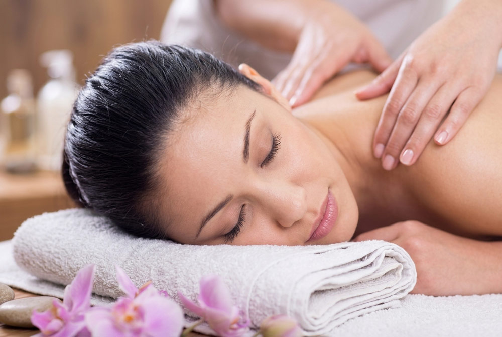 Woman lying comfortably on a massage table receiving a gentle back massage during a mobile postnatal massage session in York.