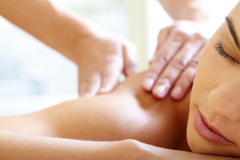 Woman Having massage to her shoulders Deep tissue shoulder massage in York delivered by a mobile therapist to relieve muscle knots and upper back tension.