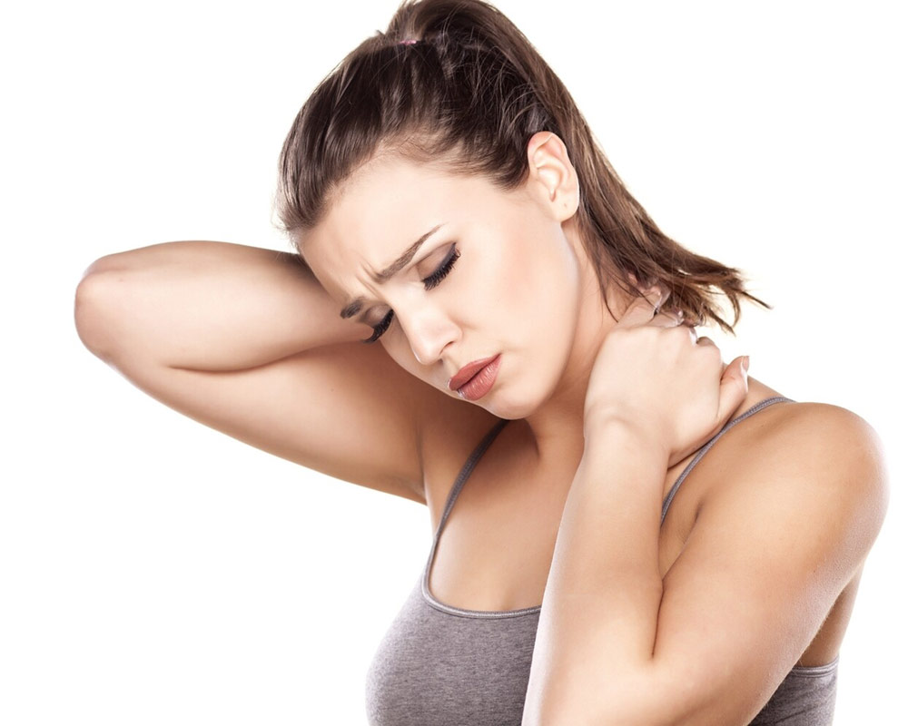 A woman suffering from a tension headache caused by neck and shoulder dysfunction, a common condition treated with mobile remedial massage in York.